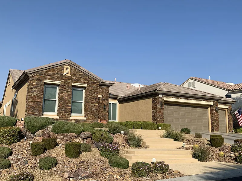 Finished stone-veneer and stucco home on a desert-landscaped slope