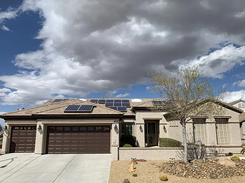 Finished home with dark brown garage doors under a cloud sky